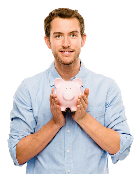 Happy young man putting money in piggy bank isolated on white - Foto, Bild