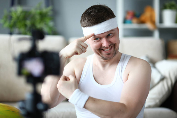 Sonriente Vlogger Mostrar músculo en la cámara digital
 - Foto, Imagen