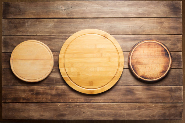 pizza cutting board at wooden plank table - Φωτογραφία, εικόνα