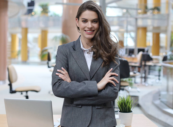 Attractive businesswoman standing near desk in the office. - Valokuva, kuva