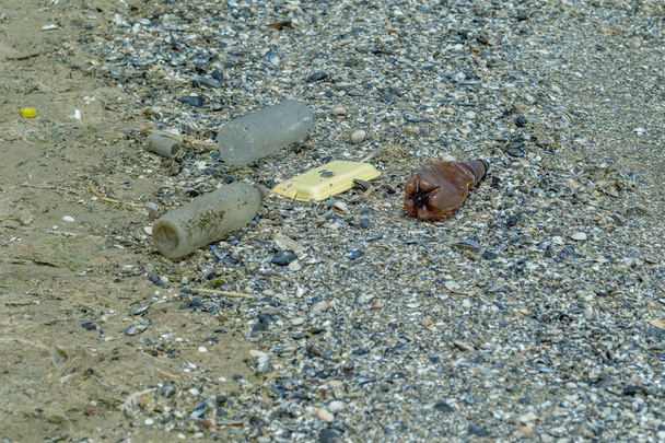 Conceitual: Desastre, Problema ambiental - lixo plástico. Derramou lixo na praia da cidade grande. Vazio usado garrafas de plástico sujo. Mar sujo, costa arenosa do Mar Negro. Poluição ambiental
 - Foto, Imagem