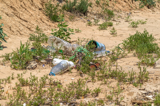 Conceitual: Desastre, Problema ambiental - lixo plástico. Derramou lixo na praia da cidade grande. Vazio usado garrafas de plástico sujo. Mar sujo, costa arenosa do Mar Negro. Poluição ambiental
 - Foto, Imagem