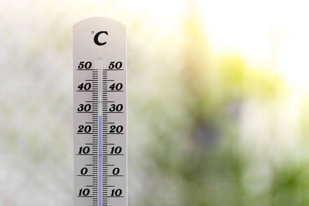 Heatwave: Thermometer in summer on a blurry background, heat - Photo, Image