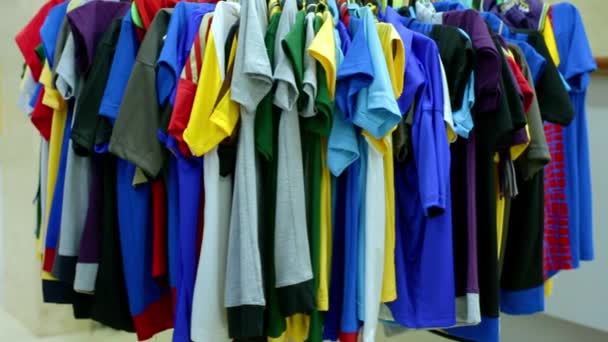 kamera mozog kerek ruhát fogas forog, élénk színű divat ruhákat a boltban - Felvétel, videó