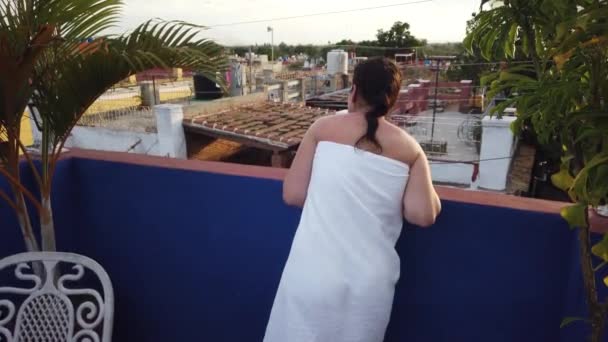Fiatal szexi nő élvezi a cigarettát egy szép tiszta design minimális környezetben. Lány dohányzik a cigarettát, miután egy zuhany a veranda a ház, a tető a ház. - Felvétel, videó