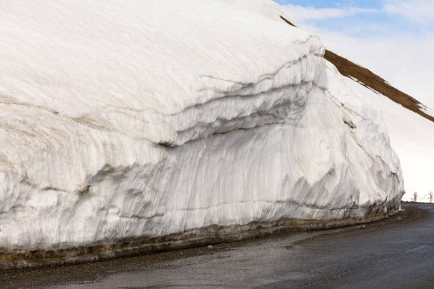 Parapeito de neve ao longo da estrada em Cross Pass da estrada militar georgiana no final da primavera. Cordilheira caucasiana
 - Foto, Imagem