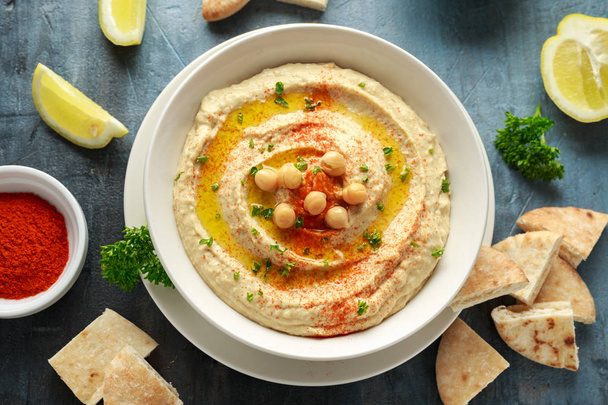 Hummus with olive oil, paprika, lemon and pita bread - Foto, afbeelding