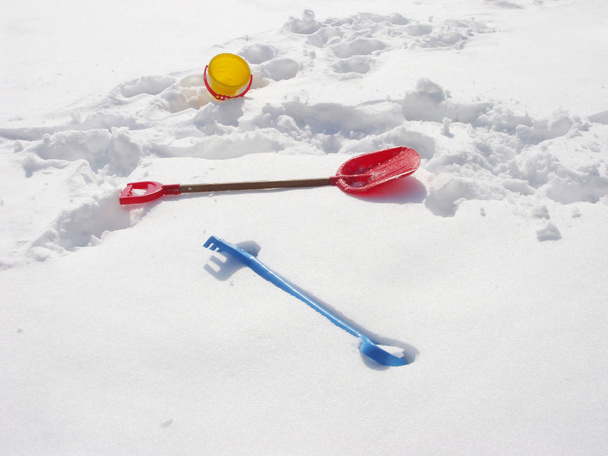 Kids winter play objects. Bucket, rake and shovel on a snow - Photo, Image
