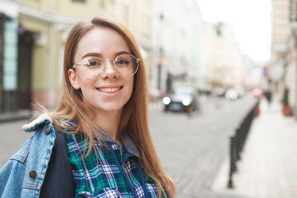 Portrait d'une belle étudiante portant une veste en jean et
  - Photo, image