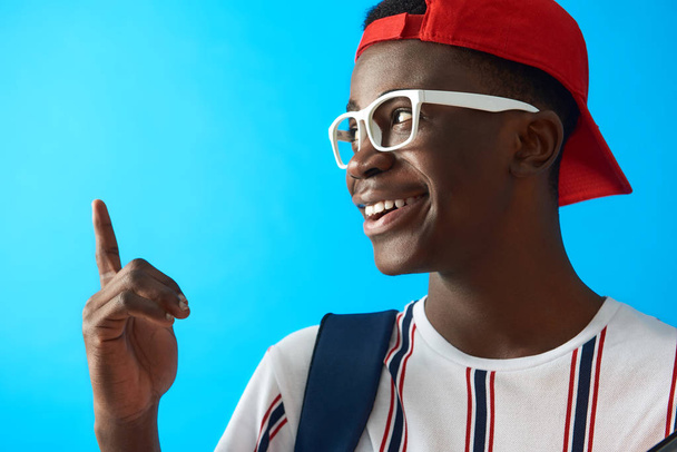 Happy Afro American student in white glasses posing in studio - Fotó, kép