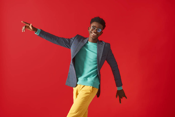 Smiling young man in glasses is making dance moves - Photo, Image