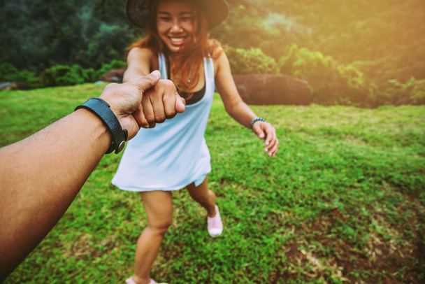 Rakastavaiset naiset ja miehet aasialaiset matkustavat rentoutumaan lomalla. Pidä kädestä kiinni nurmikolla. Villi luonto puu vuorella
. - Valokuva, kuva