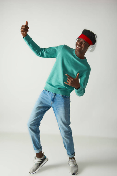 Happy young guy with red bandage is dancing - Photo, image