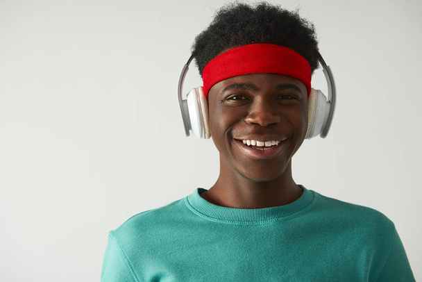 Smiling Afro American guy is using headphones - Photo, Image