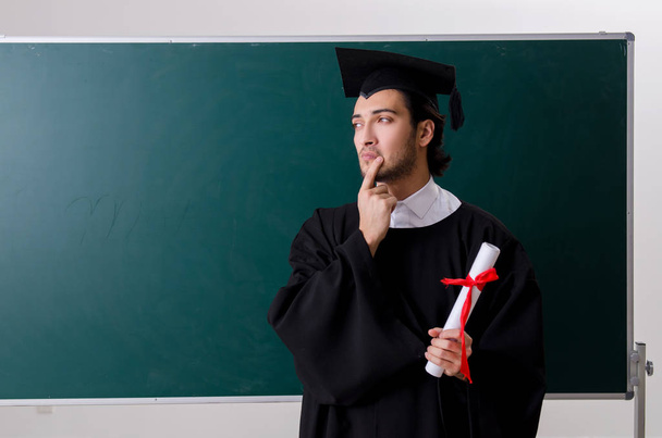 Estudante graduado na frente do quadro verde
  - Foto, Imagem