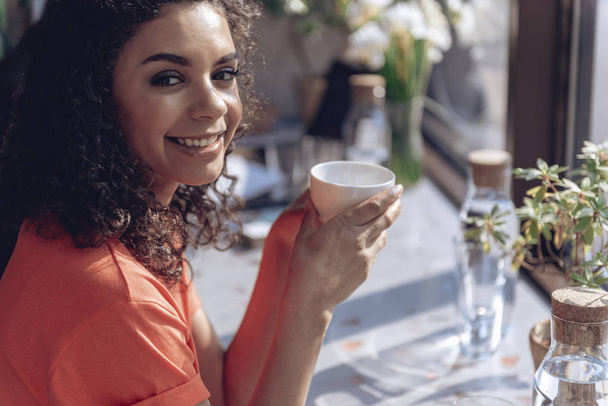 Happy girl is drinking coffee in restaurant - Fotoğraf, Görsel