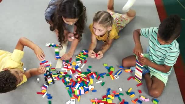 Niños jugando con juguetes de bloque, vista superior
. - Imágenes, Vídeo