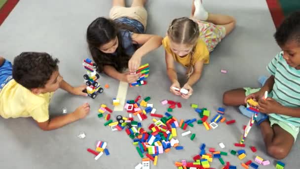 Παιδιά προσχολικής ηλικίας παίζοντας με παιχνίδια στο πάτωμα. - Πλάνα, βίντεο