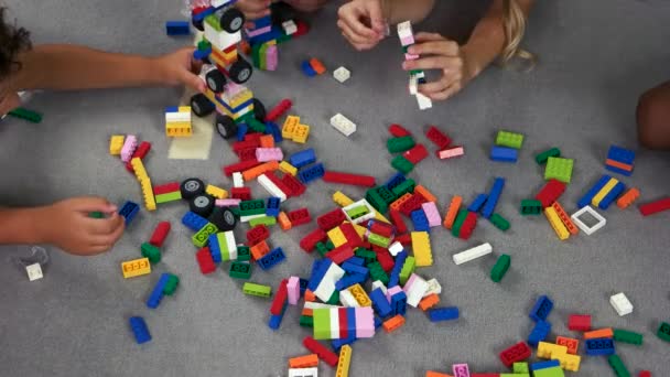 Gyerekek játszanak színes kivitelező a padlón. - Felvétel, videó
