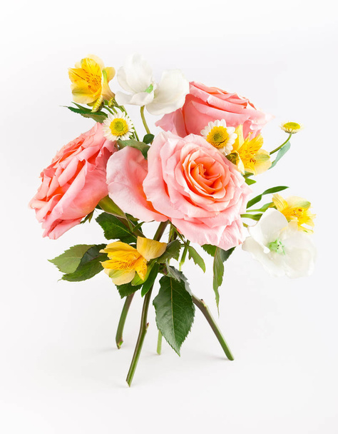 Beautiful bunch with coral roses with green leaves on white back - Fotó, kép