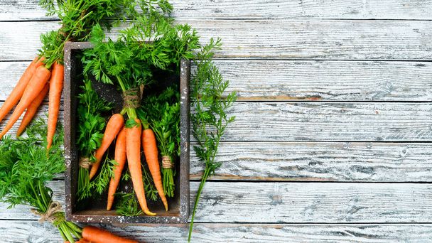 Fresh carrots on a white wooden background. Top view. Free space for your text. - 写真・画像