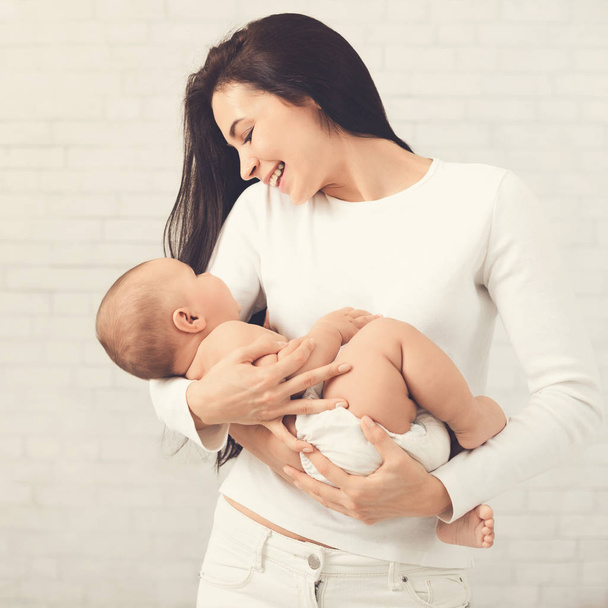 junge Mutter umarmt ihr süßes Neugeborenes - Foto, Bild
