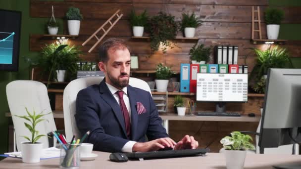 Zoom in der Aufnahme eines Geschäftsmannes, der allein im Büro mit modernem Design arbeitet - Filmmaterial, Video