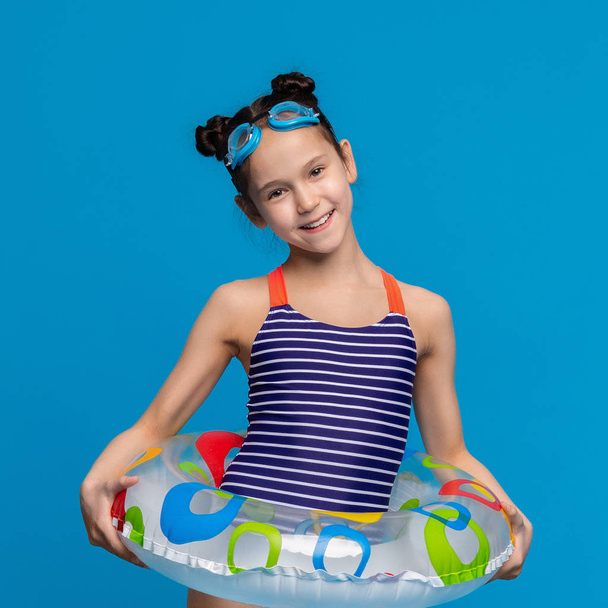 Little girl wearing inflatable ring and swim goggles - Photo, Image