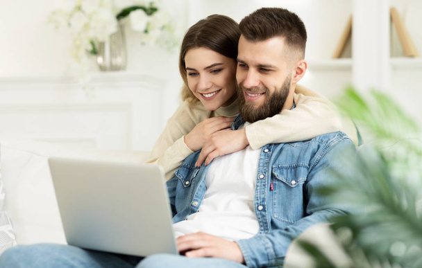Amando casal tendo vídeo-chamada no laptop, relaxando em casa
 - Foto, Imagem