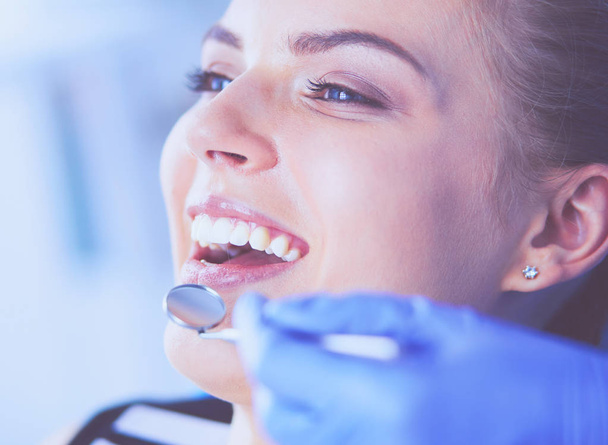 Young Female patient with open mouth examining dental inspection at dentist office. - Photo, Image