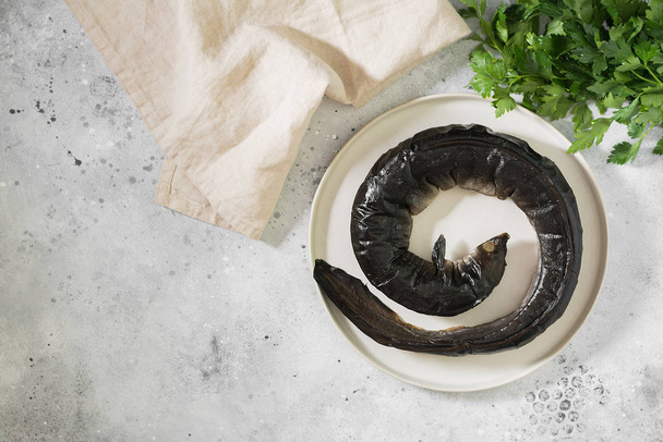 Eel fish in white plate on light background - Foto, afbeelding