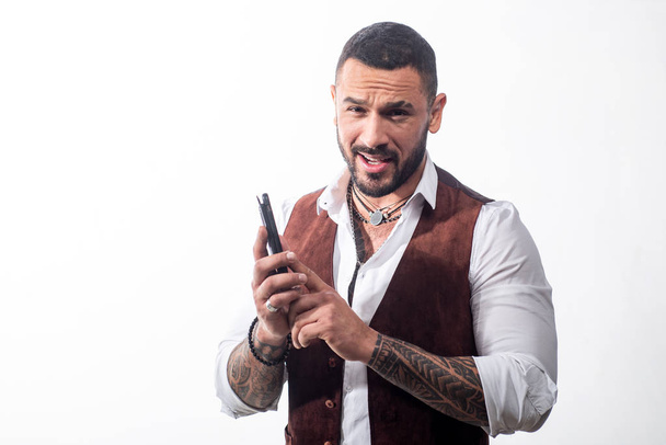 Masculinity concept. Portrait of sexy handsome fashion man model with confident expression, dressed in elegant white shirt, looks at camera, having a phone talk. Brutal bearded boy with tattoo - Photo, Image
