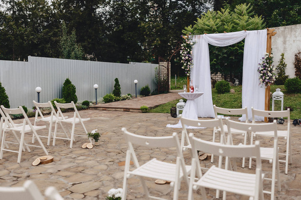 διακόσμηση τελετή γάμου, καρέκλες, τόξα, λουλούδια και διάφορα διακόσμηση - Φωτογραφία, εικόνα