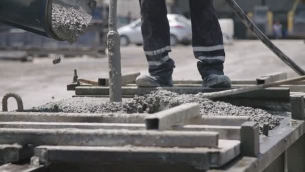 Trabajadores vertiendo hormigón en grandes moldes de acero en un sitio de construcción
 - Imágenes, Vídeo