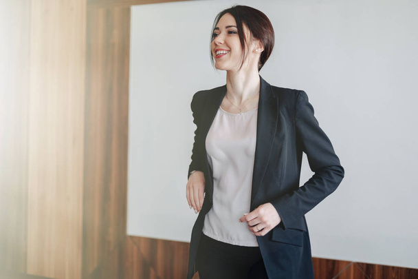 Young attractive emotional girl in business-style clothes on a plain white background in an office or audience - Fotografie, Obrázek