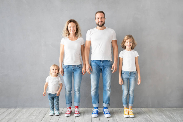 Happy family standing against grey background - Foto, Imagen