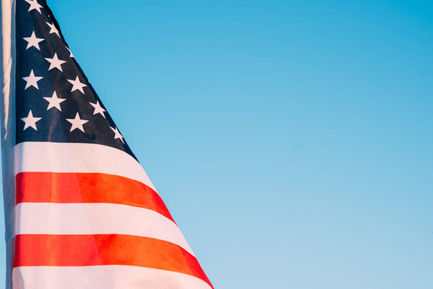 Αμερικάνικη σημαία σε γαλάζιο ουρανό, κοντά. Σύμβολο της ανεξαρτησίας DA - Φωτογραφία, εικόνα