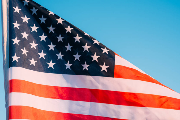 American flag in a blue sky, close up. Symbol of Independence Da - Фото, изображение