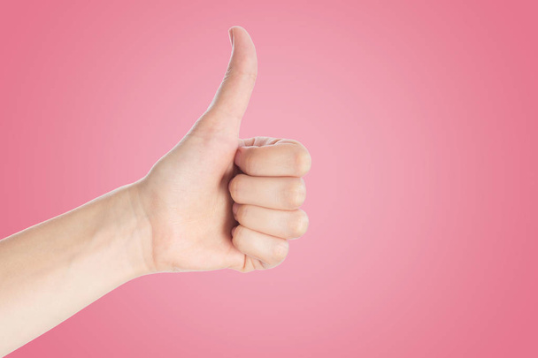 Positive gesture on a pink background. Hand show thumbs up sign, - Photo, Image
