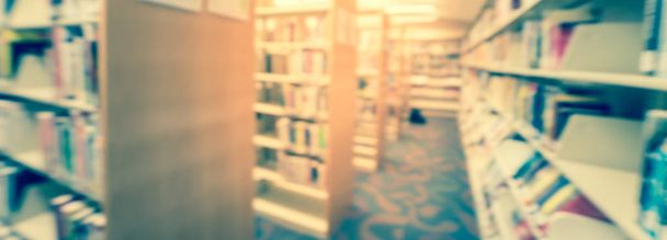 Vista panorámica borrosa pasillo de fondo de la estantería con taburete de paso en la biblioteca pública en Estados Unidos
 - Foto, imagen