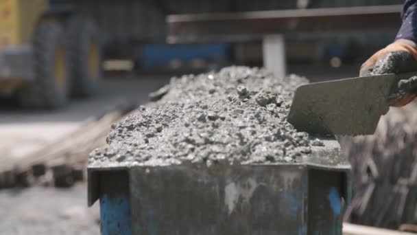 Workers pouring concrete into large steel molds on a construction site - Felvétel, videó