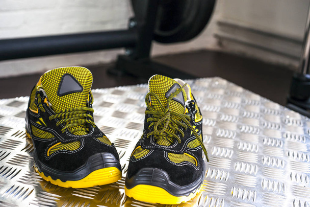 Неклейменные современные кроссовки в спортзале. Чёрно-жёлтый. Удобная обувь
. - Фото, изображение