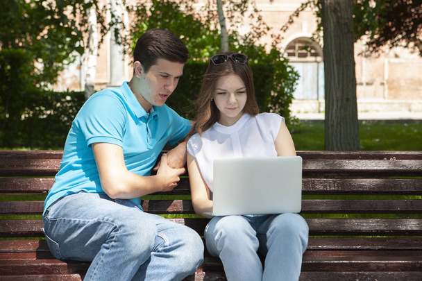 Young handsome couple using notebook in the public park - Foto, immagini