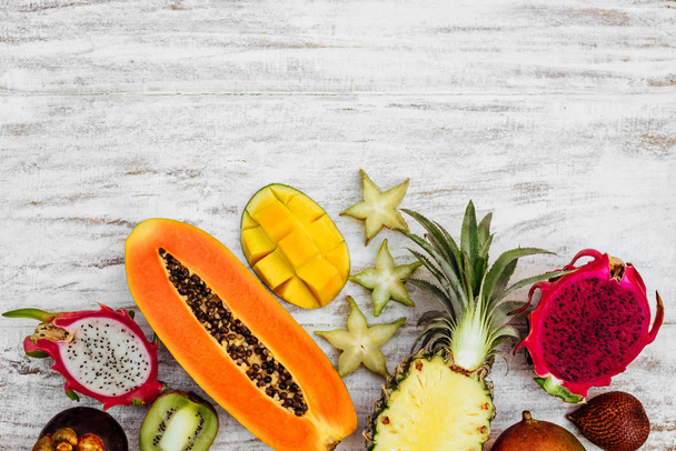 Tropical fruit on white wooden background - Foto, Imagen
