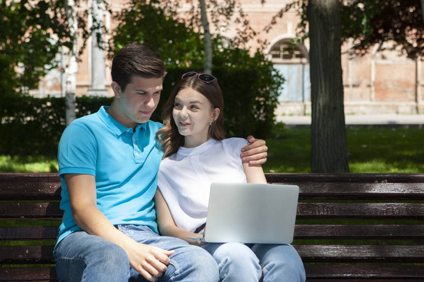 Young handsome couple using notebook in the public park - Foto, immagini
