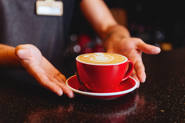 Female hands hold cappuccino or coffee cup - Фото, изображение