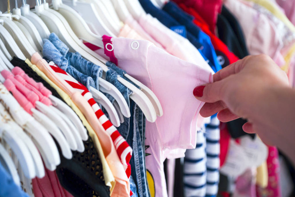 Set of clothes for kids on hangers. Shopping. - Fotó, kép