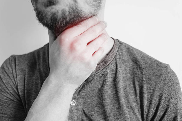 Sore throat of a men. Touching the neck. Red dot - Photo, image