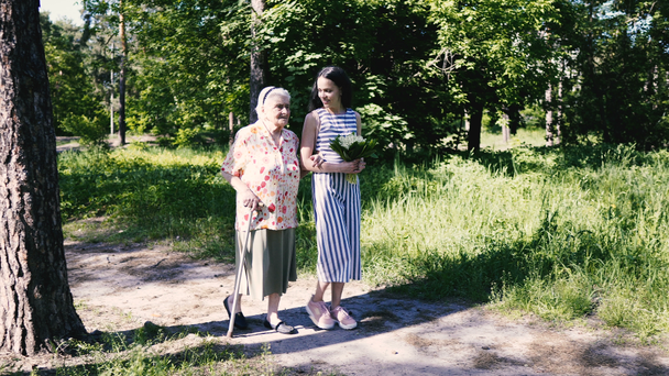 Nagymama és unokája. Nagymama és unokája sétálnak a parkban. - Felvétel, videó