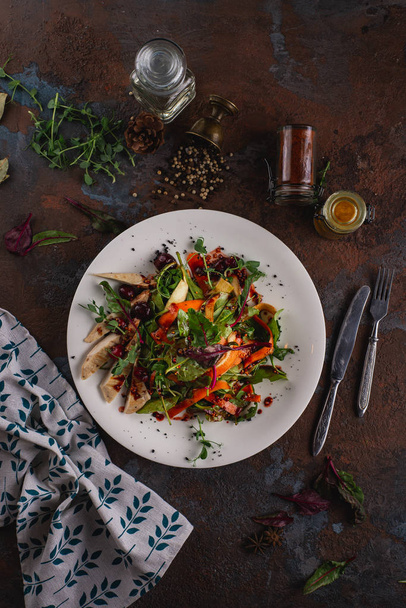 Овощной салат с курицей на белой тарелке на ржавом фоне
 - Фото, изображение